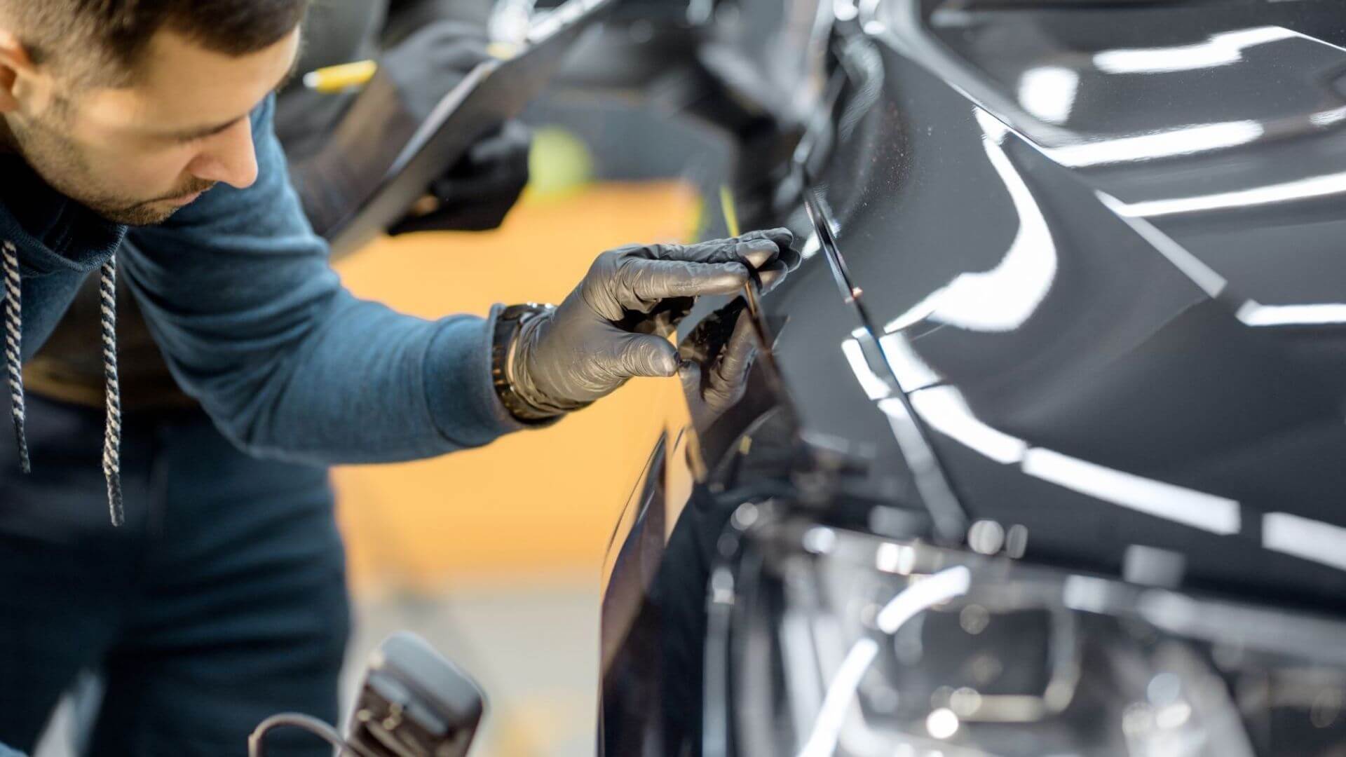 Auto body repair technician inspecting vehicle panel alignment after collision repair in Phoenix, AZ.