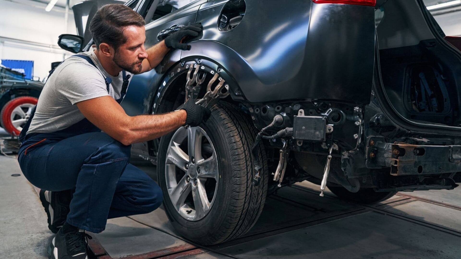 Auto body repair technician inspecting collision damage before repairs in Phoenix, AZ.
